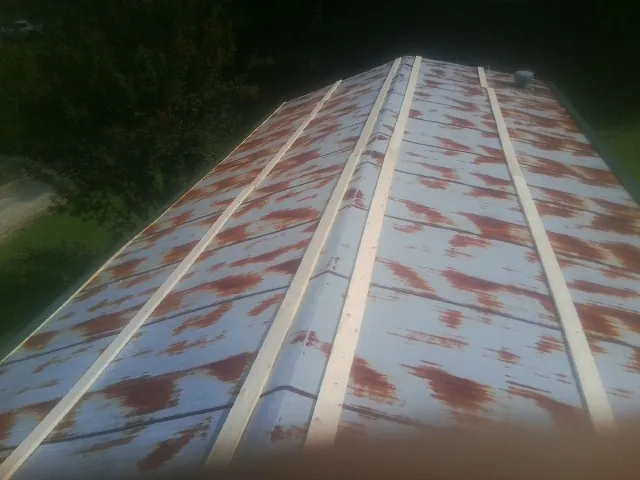 Rusted metal roof panels with new wood purlins before replacement — Storm Damage Roof Repair in Olalla by Roofing Brothers