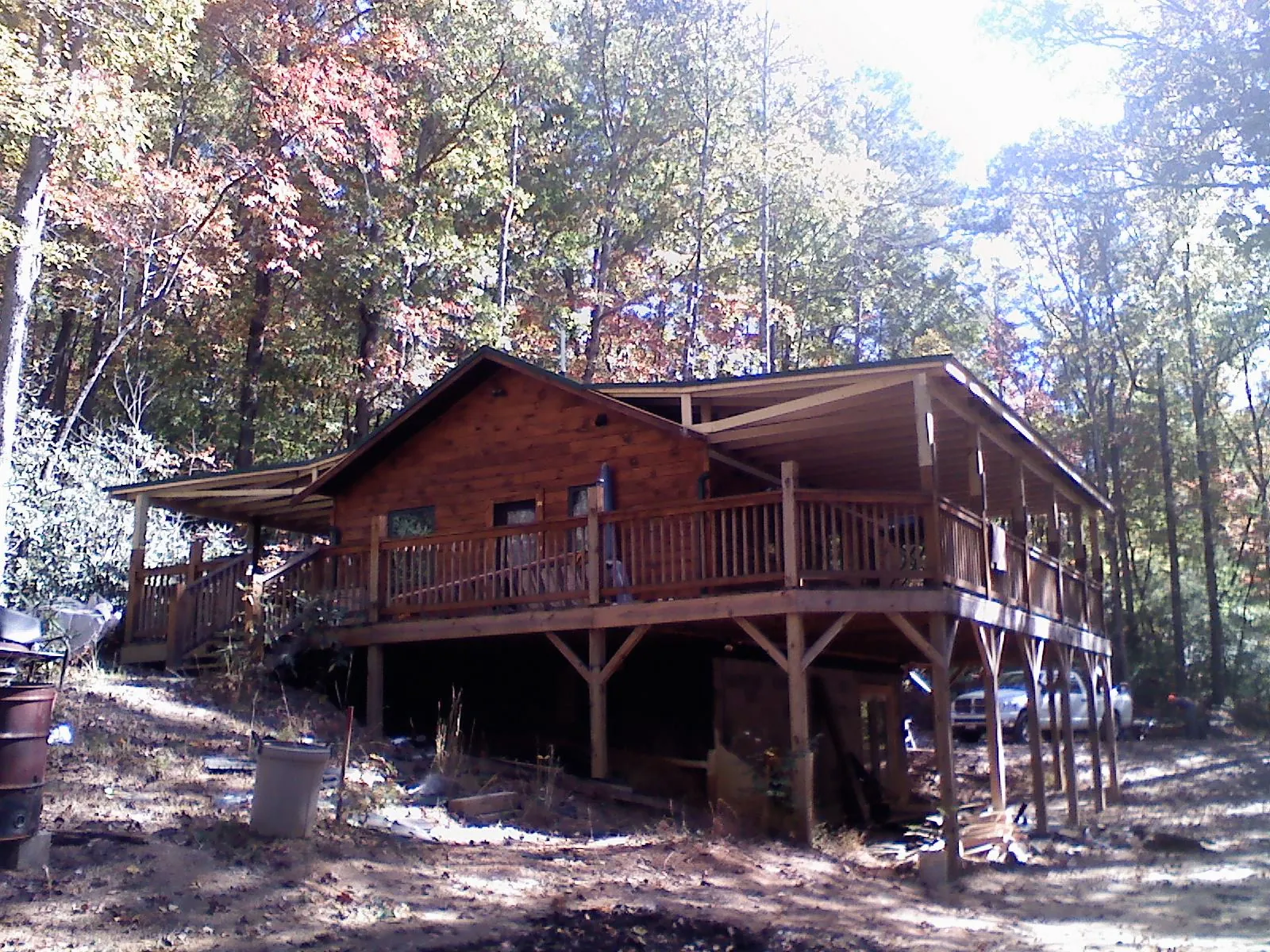 Log cabin with a wraparound porch and metal roof in the fall in Olalla