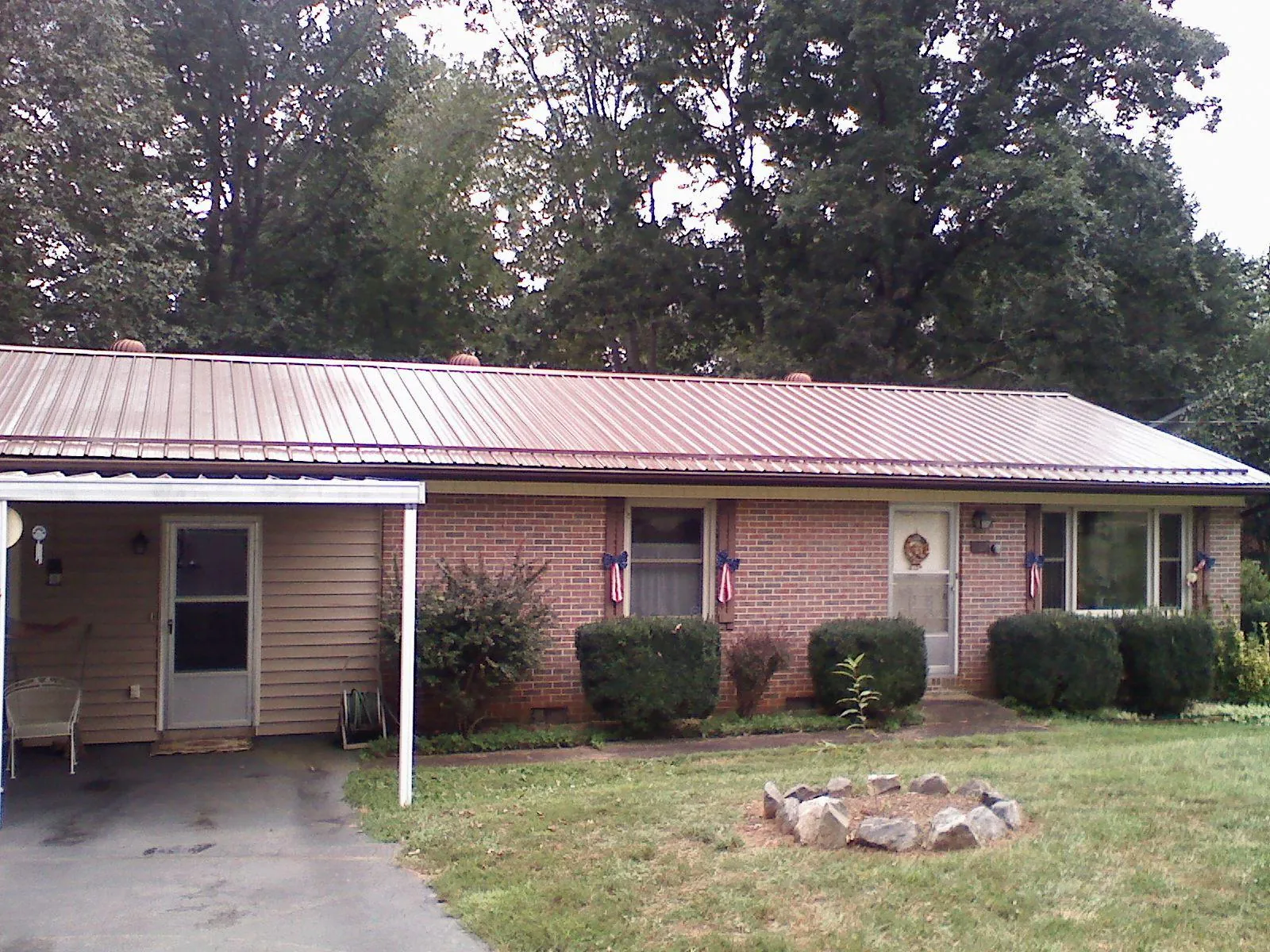 Bronze metal roof and carport on a brick ranch home — Roof Repair work by our crew in Olalla